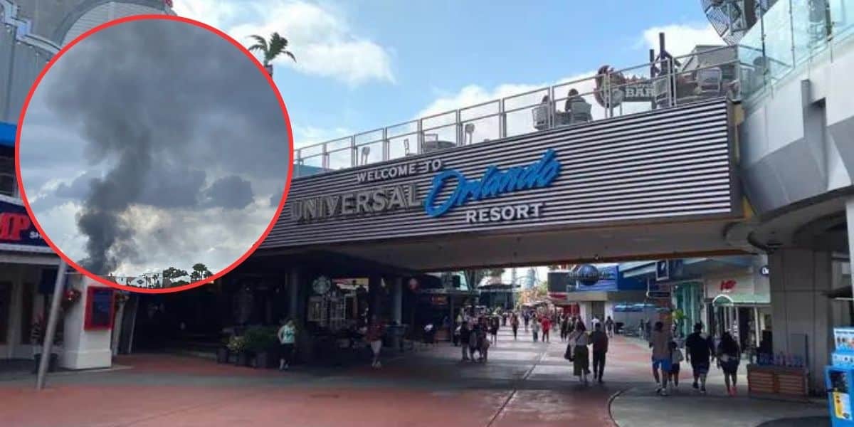 A view of the entrance of Universal Orlando Resort. The foreground shows people walking toward the entrance, which is a large overhanging structure with the words "Welcome to Universal Orlando Resort." Off to the left in the sky, dark clouds and smoke are visible.