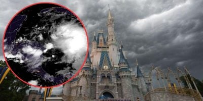 Image of a castle under dark, stormy clouds with an inset showing a satellite image of a storm system. The castle, reminiscent of Disney World grandeur, has blue and gold accents, and the atmosphere appears foreboding due to the approaching storm. Guests may find it an unforgettable part of their vacation at Disney World.