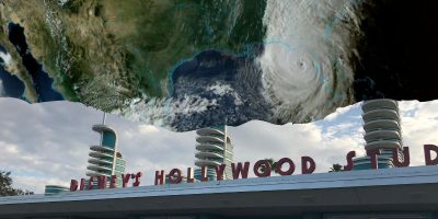 A satellite image showing a large hurricane over the southeastern United States is superimposed above the entrance of Disney's Hollywood Studios, with its iconic art-deco architectural elements and Disney sign visible underneath a cloudy sky.