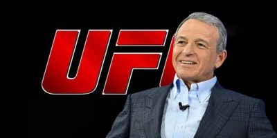 A smiling Bob Iger in front of the UFC logo.