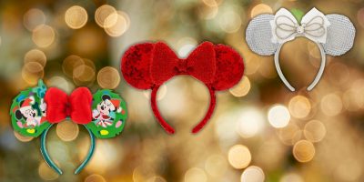 Three festive Disney ear headbands are displayed. The first is green with a red bow and Mickey design, the second is red with sequins, and the third is silver with a white bow. The background features a warm, magical bokeh light effect.