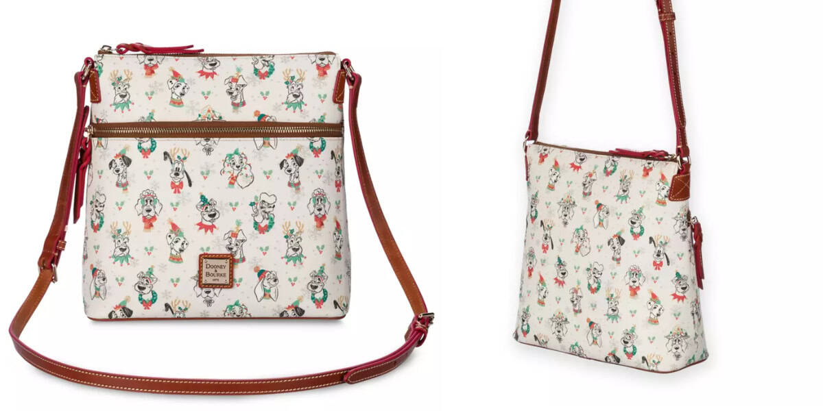 A white, square-shaped crossbody bag with a brown adjustable strap. The bag features a pattern of playful Disney Dogs in various outfits and activities. There is a front zipper pocket with a Dooney & Bourke brand label below it. The back view shows a clean design, perfect for the Holiday Collection.