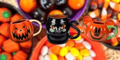 Three Halloween-themed mugs are displayed: a jack-o'-lantern, a black cat, and Mickey mugs designed like pumpkins with mouse ears. They sit amidst candy corn and assorted Halloween treats in colorful bowls, capturing the playful spirit of Spooky Season.