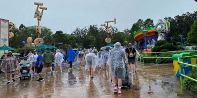 Guests in ponchos in the rain in Toy Story Land at Disney World's Hollywood Studios. Florida theme park rain