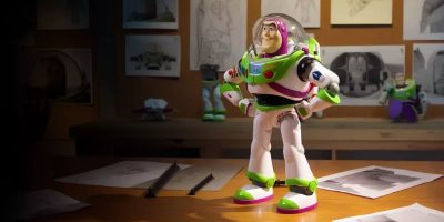 A Buzz Lightyear toy stands on a desk surrounded by sketches, as if contemplating strategies for an automated drafting system. The dimly lit room is filled with artwork, and the lighting emphasizes the toy's vibrant colors, reminiscent of drafting plans in an artist's creative domain.