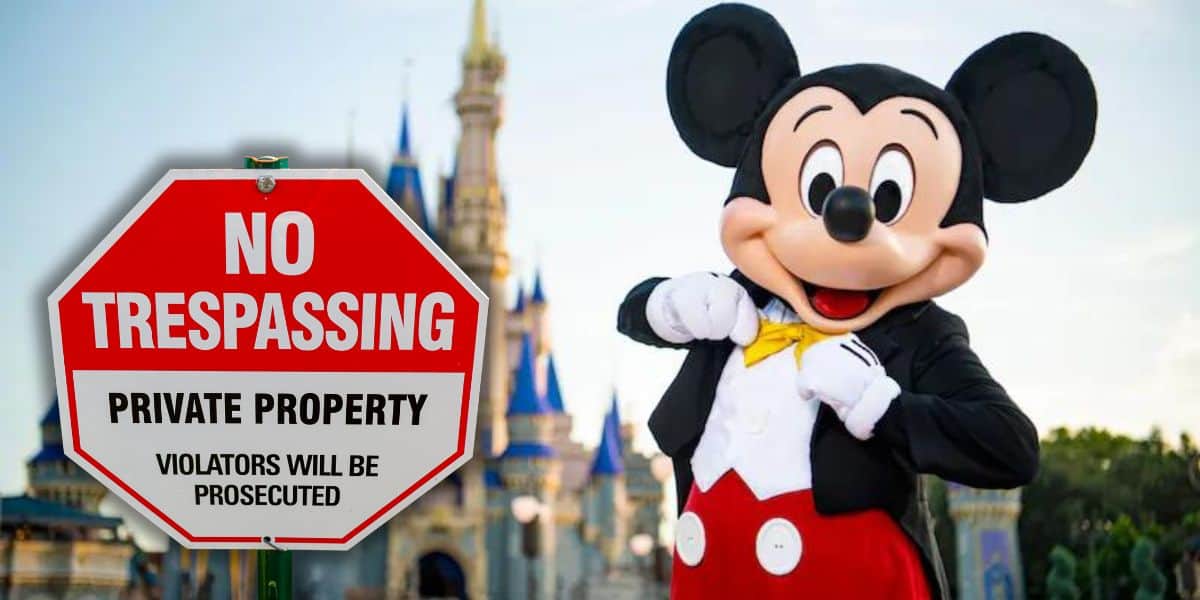 Mickey Mouse stands in front of a castle at Disney World, wearing his classic outfit. A large red octagonal sign in the foreground reads "No Trespassing, Private Property, Violators Will Be Prosecuted.