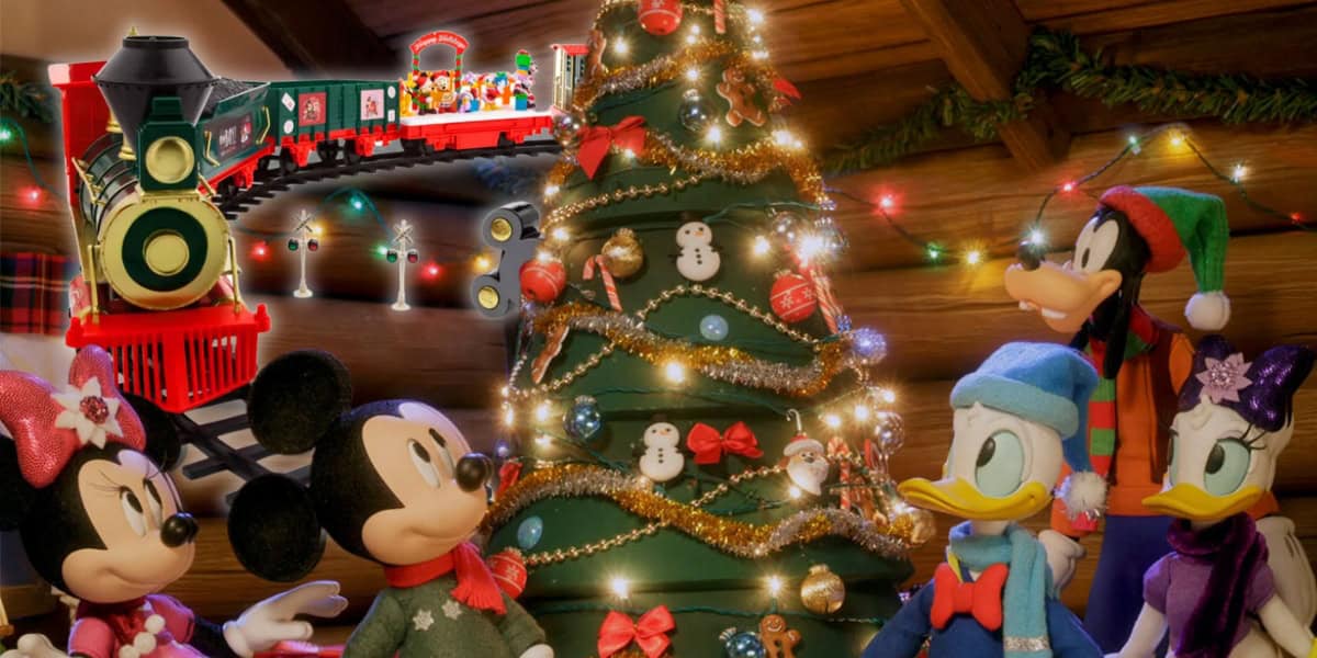 Mickey Mouse and his friends gather in a festive cabin setting, admiring a beautifully decorated Christmas tree. A charming Christmas train set circles above as the room glows with colorful lights and ornaments, creating a cheerful holiday atmosphere.