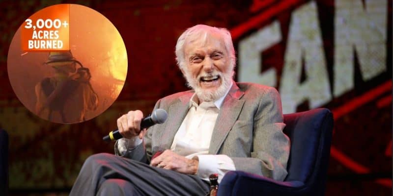 Dick Van Dyke, the 98-year-old icon with white hair and a beard, smiles while seated, holding a microphone. Inset shows a firefighter in action with "3,000+ acres burned" text over a background of flames.