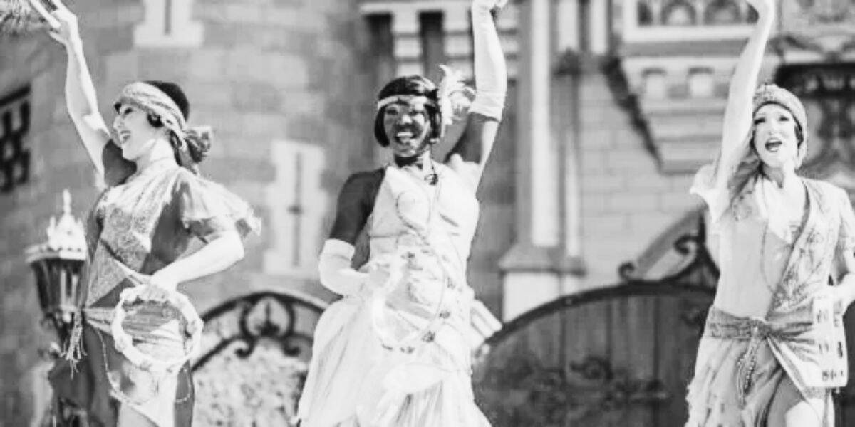 A black and white image of Princess Tiana and two dancers in front of Cinderella Castle.