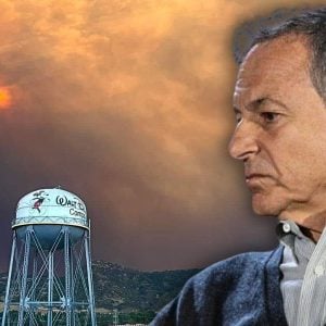Disney CEO Bob Iger in a gray sweater is shown in profile against a backdrop of a dramatic smoky sky with a faint sun. In the foreground, there is a silver water tower labeled "Walt Disney" with an image of Mickey Mouse.
