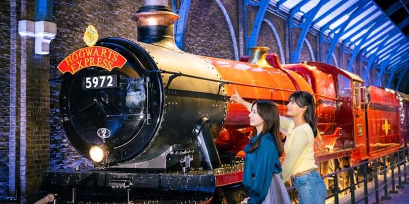 Guests stand next to the Hogwarts Express at the Warner Bros. Studio Tour in Tokyo