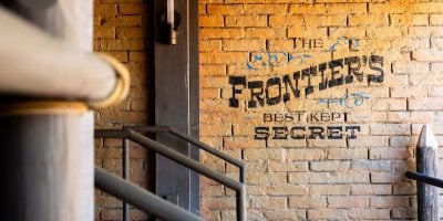 brick wall that says "The Frontier's Best Kept Secret" in Magic Kingdom