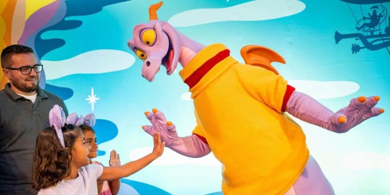 Figment high-fiving a child guest at the Disney World park EPCOT, where dozens of Disney World rides live.