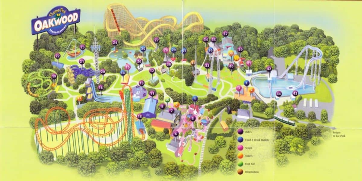 Illustrated map of Oakwood Theme Park. The map shows various rides, pathways, and attractions in a colorful layout. Key areas are numbered, and a legend indicates locations of rides, food outlets, shows, toilets, and other facilities in the park.