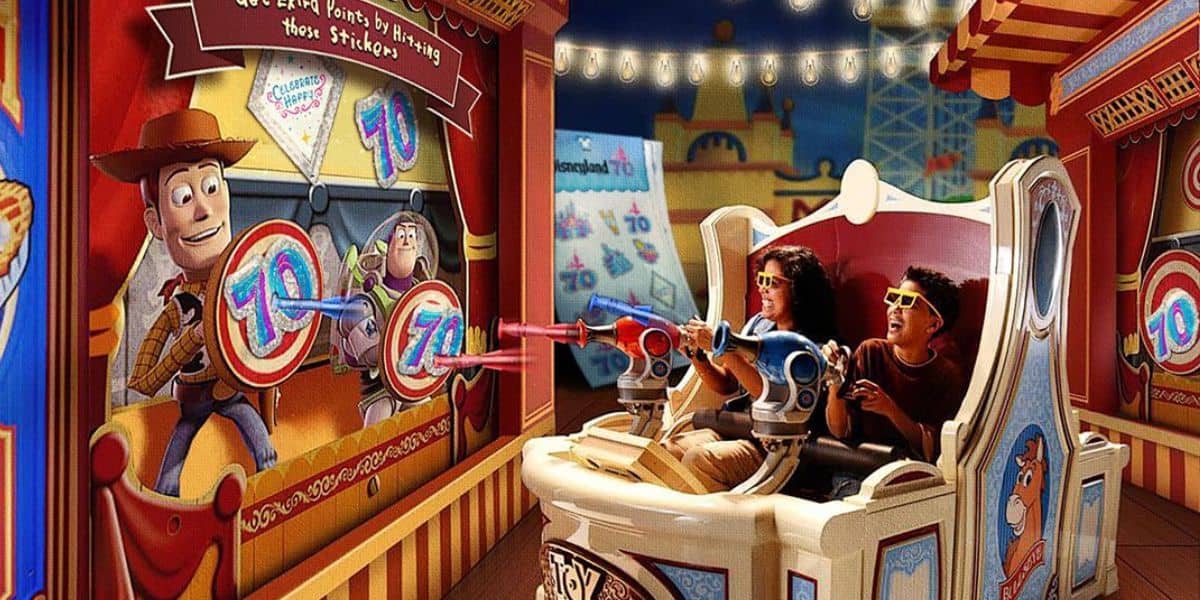 Disney fans on an amusement park ride wearing 3D glasses aim toy blasters at a screen with cartoon targets, evoking the playful spirit of Toy Story Midway Mania. The scene bursts with color, adorned in carnival decorations and an engaging game-focused atmosphere.