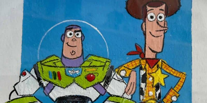 A colorful drawing of Buzz Lightyear and Woody, beloved Disney characters, standing side by side and smiling against a blue background—a heartwarming cause for any Toy Story fan to remember.