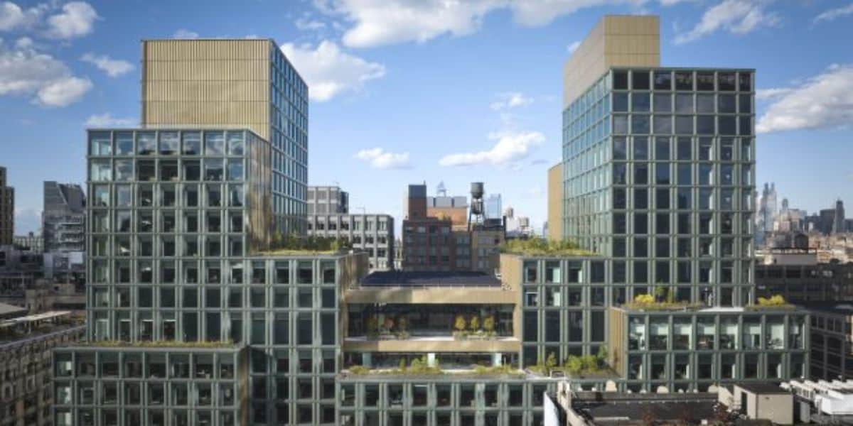 The modern urban skyline showcases high-rise buildings with glass exteriors and rooftop gardens, including the impressive Disney headquarters. The clear sky, dotted with scattered clouds, serves as a perfect backdrop as the cityscape stretches into the distance.