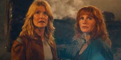 L to R: Laura Dern as Ellie Sattler and Bryce Dallas Howard as Claire Dearing facing the Giganotosaurus in 'Jurassic World Dominion'