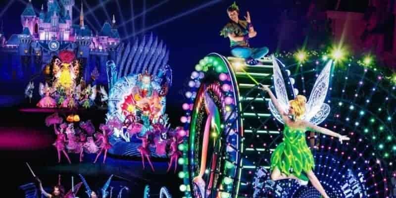 Tinker Bell and Peter Pan on a glowing float, bright lights in the Paint the Night Parade