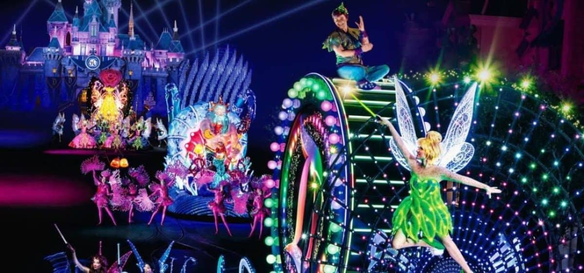 Tinker Bell and Peter Pan on a glowing float, bright lights in the Paint the Night Parade