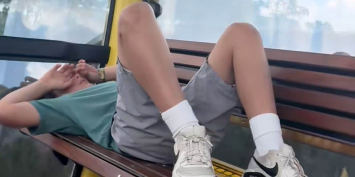 A boy laying down in a Disney Skyliner gondola