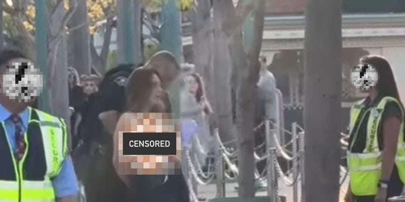 Police making an arrest of a half-nude (censored) woman at Disneyland Resort.