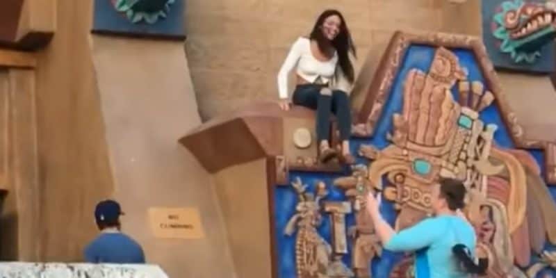 A woman sitting on top of a "no climbing" area on the pyramid in the EPCOT World Showcase Mexico Pavilion