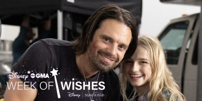 Sebastian Stan smiles beside a young blonde girl at a Disney Make-A-Wish wish-granting event.