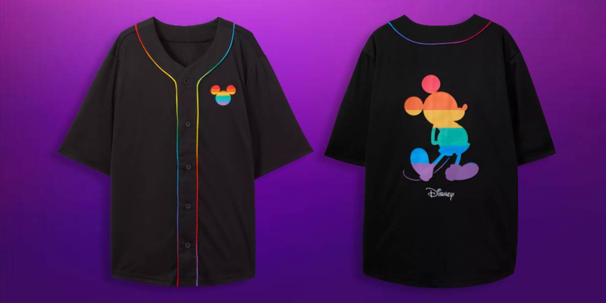 A black button-up shirt with rainbow piping and a rainbow-colored Mickey Mouse silhouette on the front and back, displayed against a purple background. The back also features a small white Disney logo—a standout piece from Disney Pride Merch.