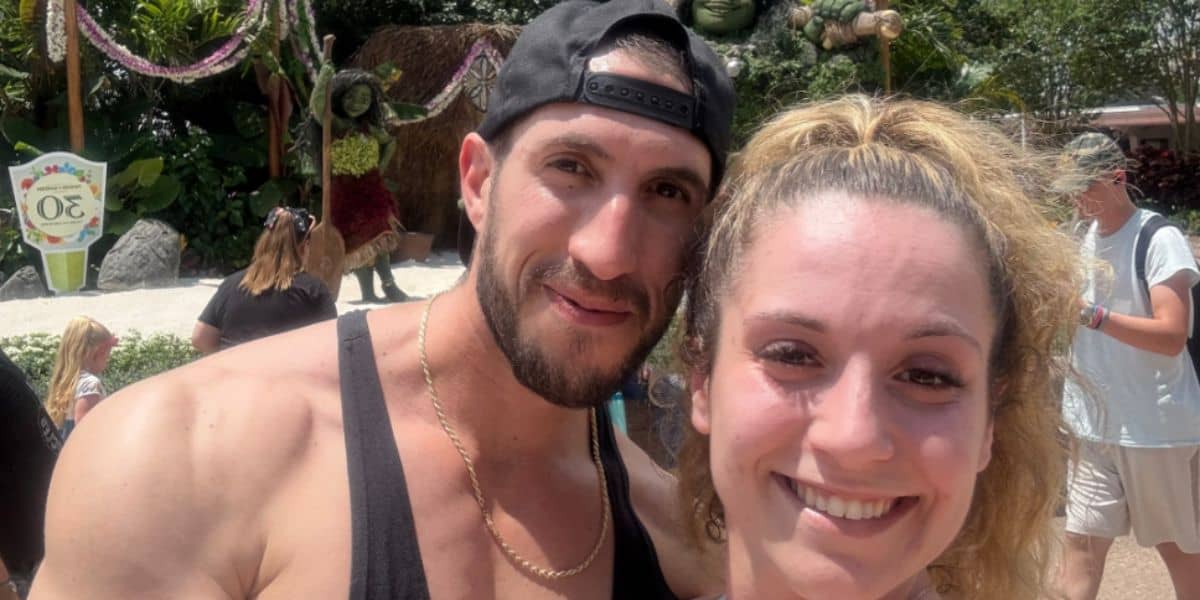 A man and a woman, both smiling. The woman is wearing a sports bra that violated the Disney Dress code.