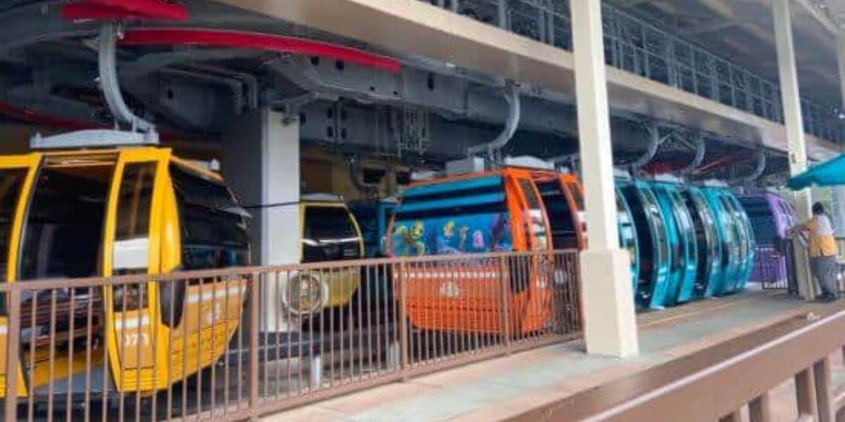 Disney Skyliner gondolas pull into a station.