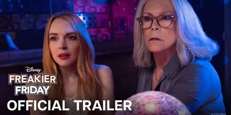 Two women sit closely together in a dimly lit room, looking surprised or concerned. One has long red hair, the other gray hair and glasses. The text reads “Disney Freaky Friday Official Trailer.”.