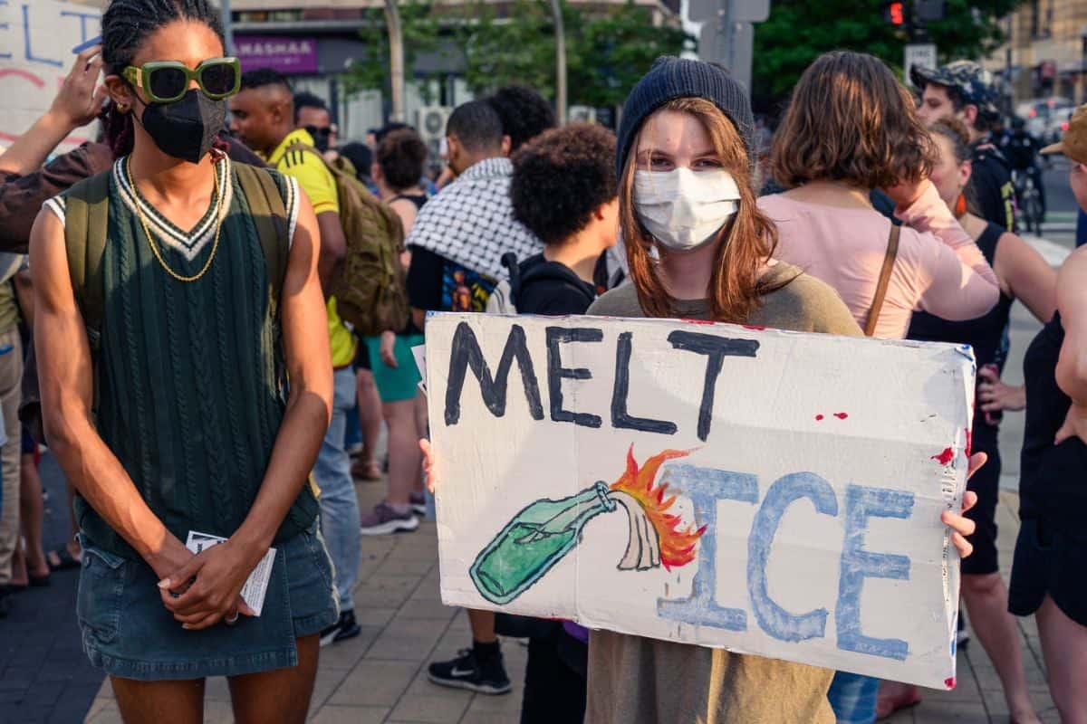 Two people in DC protesting ICE activity in Los Angeles, not far from Disneyland Resort.