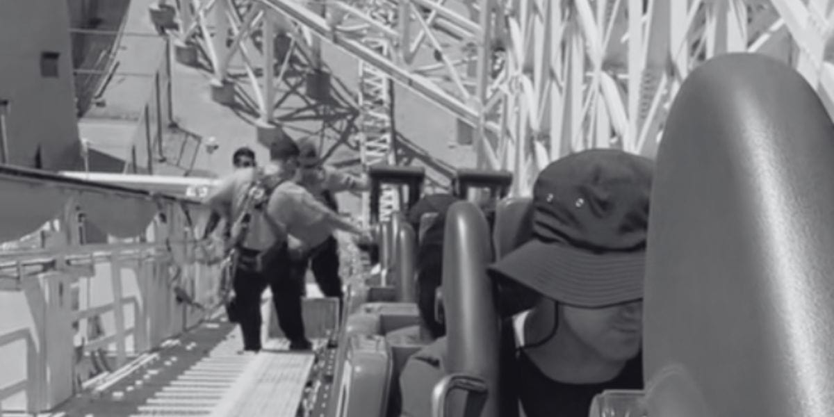 A black and white photo shows people stuck on the Incredicoaster as cast members help them evacuate.