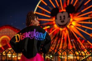 A woman wears a Disneyland spirit jersey in front of California Adventure ferris wheel