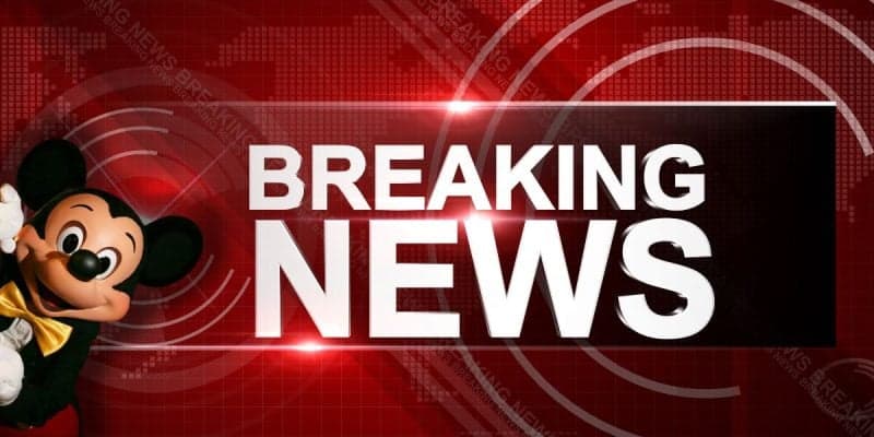 Mickey Mouse appears on the left side of a red background with digital patterns, next to a large white "BREAKING NEWS" headline in bold letters as Disney World guests are urged to remain home.