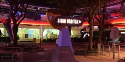 A glowing sign reading "Astro Orbiter" at night in Tomorrowland at Magic Kingdom.