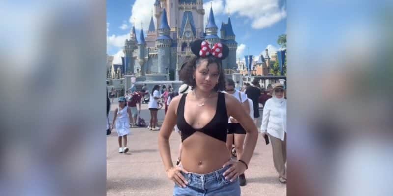 A young woman in front of Cinderella Castle in the shirt that violated the Disney dress code.