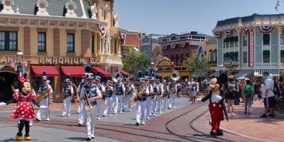 Mickey and Minnie Mouse lead a marching band at on Main Street, U.S.A., at Disneyland Park.