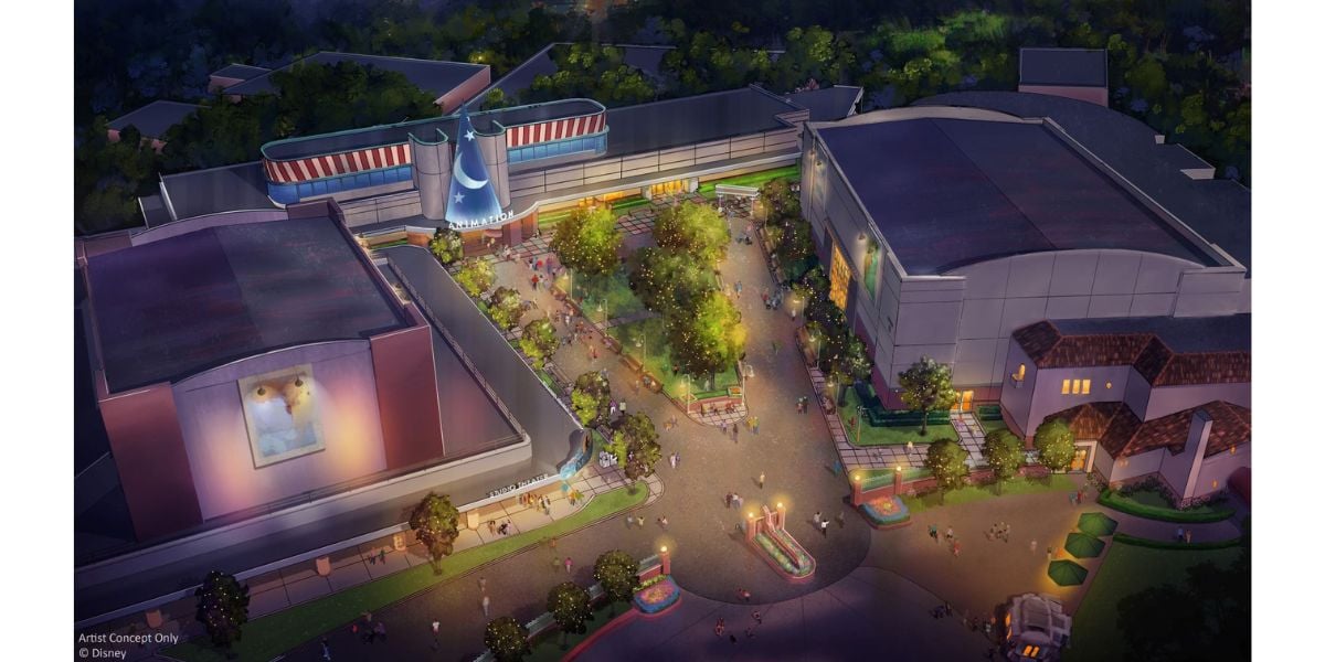 An aerial, illustrated nighttime view of a theme park area with trees, winding paths, and glowing lights, surrounded by large buildings—one featuring a giant sorcerer's hat and another displaying a poster of a cartoon dog.