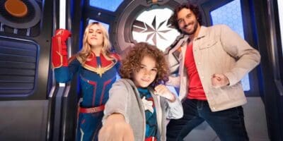 Captain Marvel posing with two guests