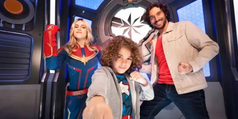 Captain Marvel posing with two guests