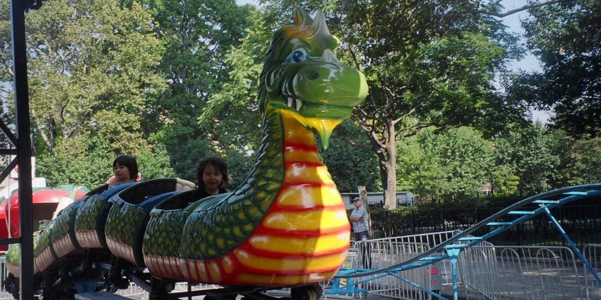 Children on a dragon-style kiddie coaster
