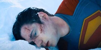 Superman in the snow with his face covered.