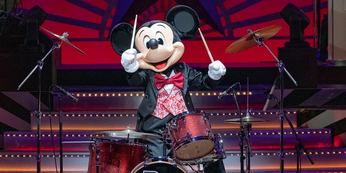 Mickey Mouse wearing a tuxedo and playing the drums onstage in Big Band Beat – A Special Treat
