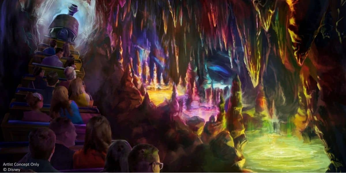 A group of people in a mine cart ride through a colorful, glowing cave—much like Big Thunder Mountain—filled with vibrant stalactites and stalagmites, all illuminated by stunning shades of purple, pink, blue, and green.