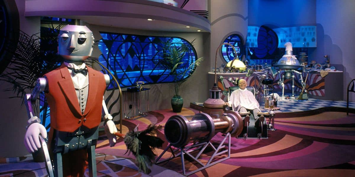 A futuristic room with a large robot in a red vest, a seated human-like figure, high-tech gadgets, and vibrant blue and purple lighting—like a whimsical, retro-futuristic scene inspired by the Best Disney World Ride.
