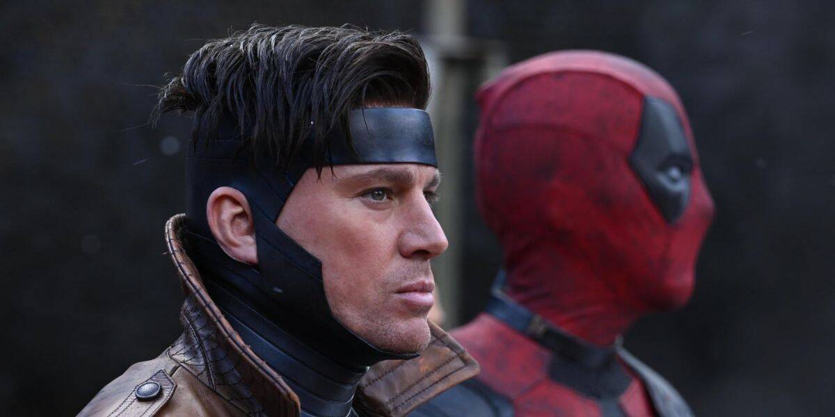 Two costumed characters stand side by side, ready for doomsday. The one in front wears a brown jacket, black headband, and has short dark hair. Behind stands a figure in a red and black suit with a full face mask. Both look serious and focused.