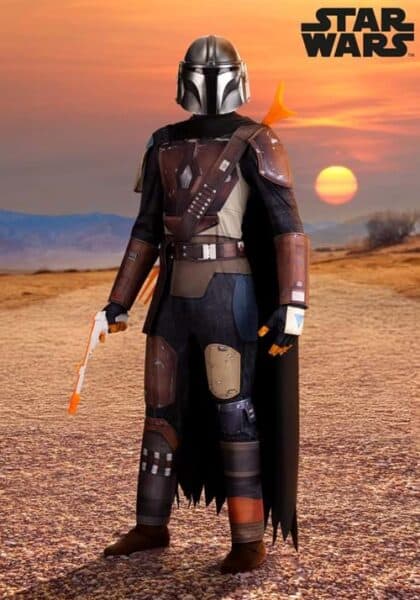 A person dressed in Mandalorian armor from Disney Costumes stands in a desert landscape at sunset, holding a toy blaster, with the Star Wars logo in the corner.