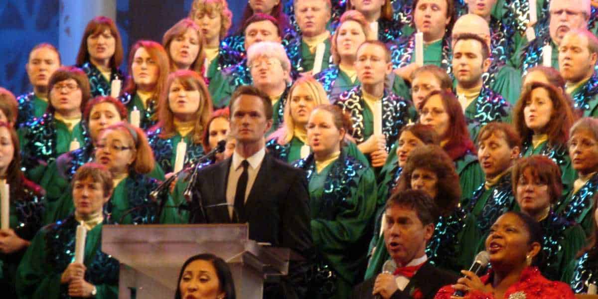 Neil Patrick Harris narrates the Candlelight Processional at EPCOT, surrounded by a large choir